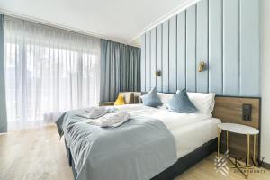 ein Schlafzimmer mit einem großen weißen Bett mit blauen Kissen in der Unterkunft Lividus 307 Świnoujscie ApartPark - KLW apartments AC in Świnoujście