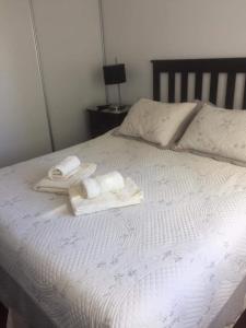 1 cama con 2 toallas y 2 almohadas en AGUAMARINA en Puerto Madryn