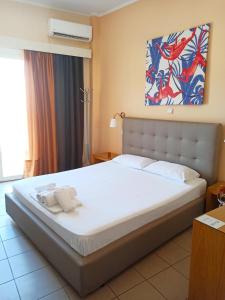 a bedroom with a large white bed in a room at Minos Hotel in Preveza