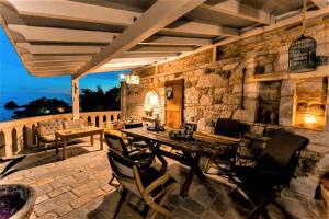 an outdoor patio with a wooden table and chairs at Villa Letista in Parga