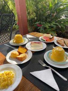 a table with plates of food on top at Pousada Flor de Debora in Alto Paraíso de Goiás +90 photos