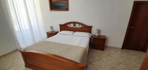 een slaapkamer met een houten bed en 2 nachtkastjes bij la casa di Maya in Napels