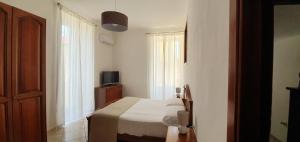 een kleine slaapkamer met een bed en een televisie bij la casa di Maya in Napels