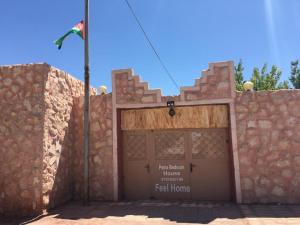 a building with a gate with a flag on top at Petra bedouin house in Al Ḩayy