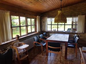 a dining room with a table and chairs and windows at Julianadorp Direkt an den Dünen in Julianadorp