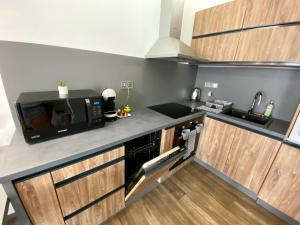 a small kitchen with a microwave and a sink at Pegazus Apartman in Keszthely