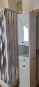 uma casa de banho com um chuveiro e um armário branco em CASA VACANZE Monte Venere em Castelmola