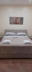 uma cama num quarto com duas toalhas em CASA VACANZE Monte Venere em Castelmola
