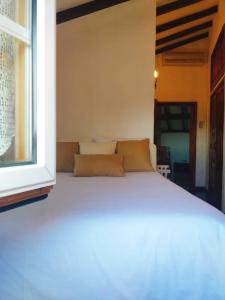 a white bed in a room with a window at Casa dos Sequeiras in Monsanto
