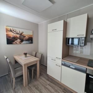 a small kitchen and dining room with a table and a microwave at Harz im Herzen in Altenau