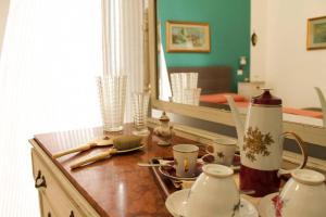 una mesa con tazas y un espejo en una habitación en A casa di Enza B&B, en Palermo