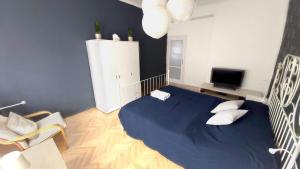 een slaapkamer met een groot blauw bed met kussens bij Eozin Apartman in Pécs