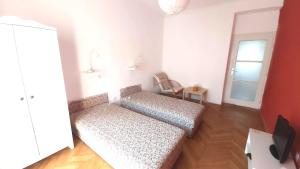 a small room with a couch and a window at Eozin Apartman in Pécs