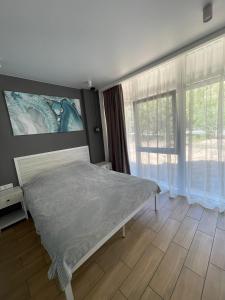 1 dormitorio con cama y ventana grande en Золотой Бугаз, Колоски, апартамент 7/1, en Karolino-Buhaz