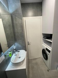 y baño con lavabo y lavadora. en Золотой Бугаз, Колоски, апартамент 7/1, en Karolino-Buhaz