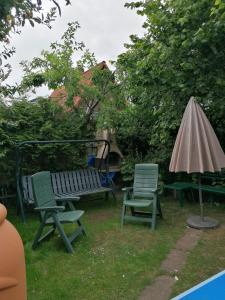 two chairs and a bench and an umbrella at Spatzennest in Garz-Rügen