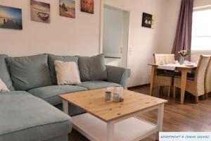 sala de estar con sofá y mesa en Ferienhaus Seeschwalbe, en Tossens