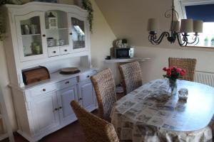 ein Esszimmer mit einem Tisch und einem Schrank in der Unterkunft Ferienwohnung Scheel in Nordstrand