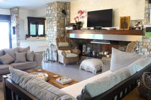 a living room with a couch and a fireplace at Elikon Luxury Villa in Methoni