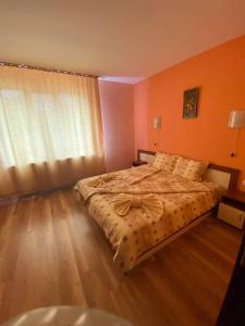 a bedroom with a large bed and a window at Guest House Kostovi in Kiten
