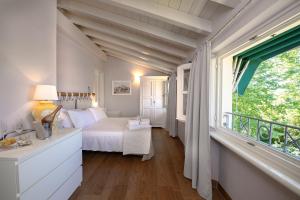 a bedroom with a bed and a large window at Relais Villa Isabel in Pietrasanta