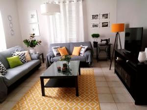 ein Wohnzimmer mit einem Sofa und einem Couchtisch in der Unterkunft Villa Rosa garden House in Korfu-Stadt