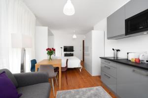 a kitchen and living room with a table and a couch at The Studios Montreux - Swiss Hotel Apartments in Montreux