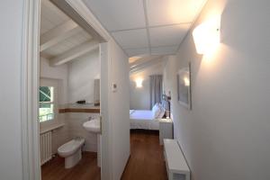 a bathroom with a bed and a sink and a toilet at Relais Villa Isabel in Pietrasanta
