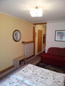 ein Schlafzimmer mit einem Bett und einem roten Sofa in der Unterkunft Apartment Barbara in Regensburg
