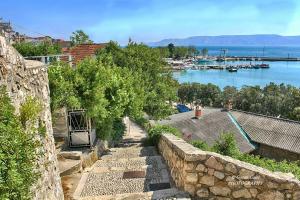a stone retaining wall with a view of a harbor at Holiday house Belavista in Novi Vinodolski
