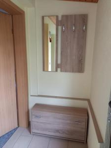 ein Badezimmer mit einer Holzkommode und einem Spiegel in der Unterkunft Ferienwohnung Kransevitz in Kransevitz