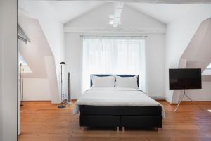 1 dormitorio con 1 cama y TV de pantalla plana en The Studios Montreux - Swiss Hotel Apartments, en Montreux