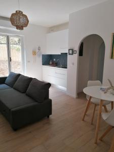 uma sala de estar com um sofá preto e uma mesa em Panoramica Flat em Porto Santo Stefano