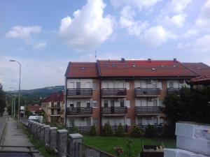 a building with a red roof on a street at Apartman Sky Banja Vrujci in Gornja Toplica