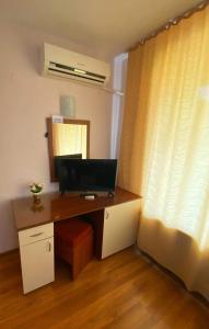 a desk with a computer in a room with a window at Guest House Kostovi in Kiten