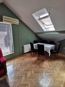 a dining room with a table and chairs and a skylight at Stan na dan Bijeljina in Nova Mahala