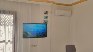 een flatscreen-tv aan een muur bij 2+1 Apartm with Garden + balcony , at Ladies beach in Kuşadası