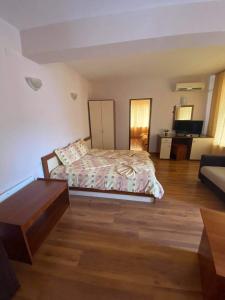 a bedroom with a bed and a living room at Guest House Kostovi in Kiten