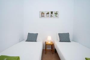 2 camas en una habitación con paredes blancas en Andaluz Apartments - Medina, en Nerja