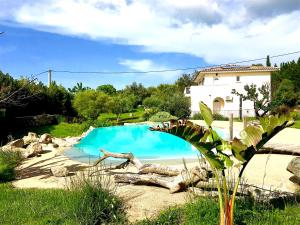 a blue swimming pool in front of a house at L'Alivi di l'Osari in Belgodère