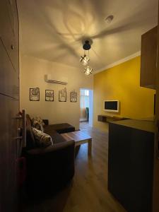 ein Wohnzimmer mit einem Sofa und einem TV in der Unterkunft BetaS GuestHouse in Antalya