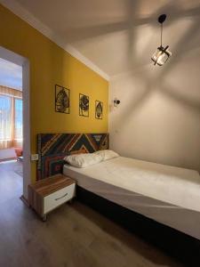 2 łóżka w pokoju z żółtymi ścianami w obiekcie BetaS GuestHouse w mieście Antalya