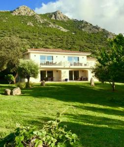 a large house in front of a mountain at L'Alivi di l'Osari in Belgodère