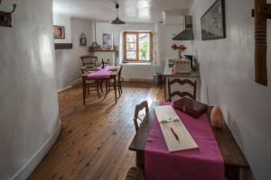 une salle à manger avec une table et des chaises violettes dans l'établissement Au Cheval Blanc - appartements et chambres d'hôtes, à Albertville