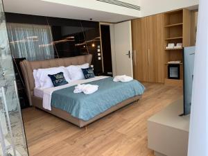 a bedroom with a bed with towels on it at Empire Beach Resort ADULTS ONLY in Dhërmi