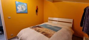 1 dormitorio con 1 cama en una pared amarilla en Surfin en Koksijde
