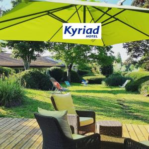 un parasol jaune kir sur des chaises et une table dans l'établissement Kyriad Angoulême Nord Champniers- Hôtel & Résidence, à Champniers