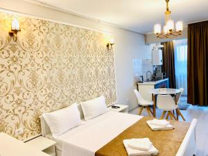 a bedroom with a bed and a table and a kitchen at Summer apartments in Eforie Nord