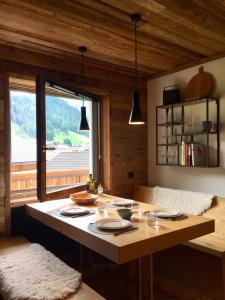 uma sala de jantar com uma mesa e uma grande janela em Dolomiti Dreams em Selva di Val Gardena