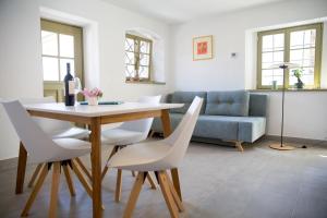 a living room with a table and white chairs at Hiša Liza in Kobarid